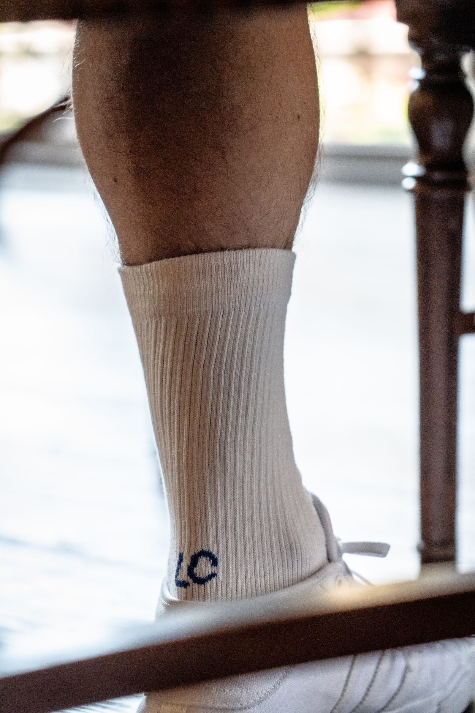 Close-up of a cream ribbed Landfeel Club sock with the LC logo knitted on the heel